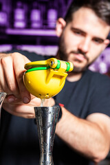 an unfocused man squeezes lemon in a bar