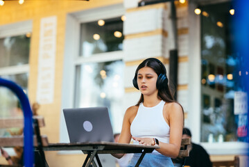 Beautiful woman working on laptop at outdoors cafe