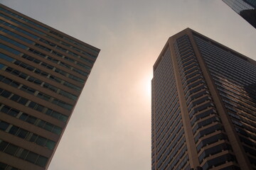 Obraz premium Top of Brick Sckyscrapers with WIndows Against Overcast Summer Sky