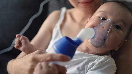 Close up view of baby breathing an inhaler 