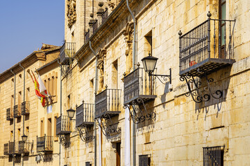 Facades of old stone buildings with their typical balconies with metal trellis in the Burgo de Osma, Soria.