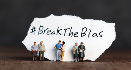 Torn paper with the word ‘BreakTheBias' written on it. Break the bias campaign with miniature...