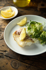 Roasted cod fillet with lemon and salad