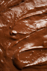 a close-up on chocolate ganache or pudding with swirls and spreads filling the frame, selective focus