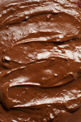 a close-up on chocolate ganache or pudding with swirls and spreads filling the frame, selective focus