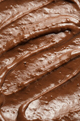 a close-up on chocolate ganache or pudding with swirls and spreads filling the frame, selective focus