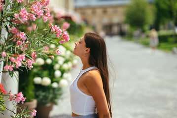 Outdoor portrait of young beautiful lady posing near flowering tree.