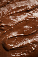 a close-up on chocolate ganache or pudding with swirls and spreads filling the frame, selective focus