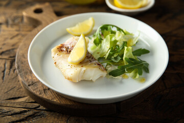 Roasted cod fillet with lemon and salad