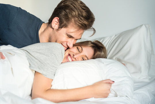 beautiful happy young couple cuddling on bed
