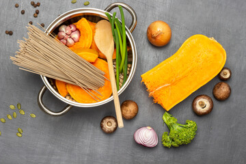 Noodles, pumpkin and chickpeas in saucepan.