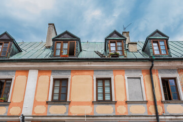 A beautiful, colorful, slightly dilapidated tenement house in the old town. The roof is covered with a zinc sheet. Zamosc, Poland