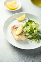 Roasted cod fillet with lemon and salad