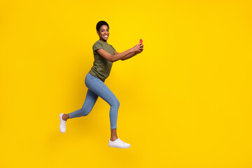 Fototapeta na wymiar Full body photo of excited person use telephone blogging jumping running isolated on yellow color background