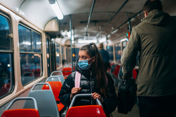 Young woman with mask traveling in the public transport.