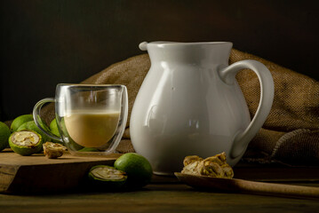 green walnut kernels leaves  wooden table oil nuts unripe husks healthy food drink, old rustic table Background Harvest, organic Homemade plant based milk Dairy free  jug glass cup