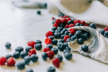 Background of juicy close-up blurred raspberries and blueberries.