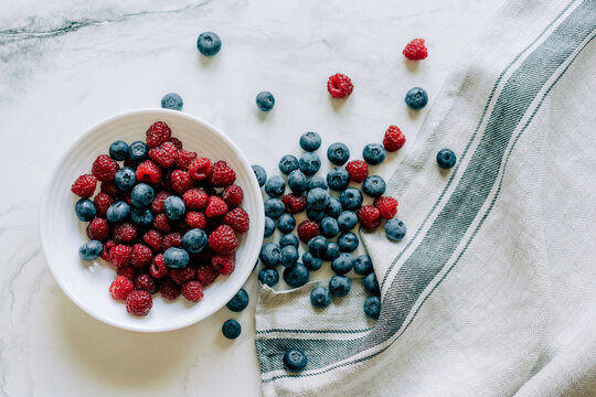 Top view of pile of fresh and healthy and berries for wellness on marble background.
