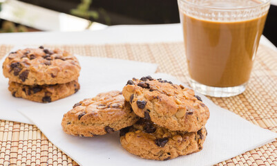cookies with chocolate and hazelnuts and coffee with milk lie on the table