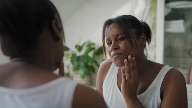 African-American woman  in the bathroom having a strong toothache or bruxism. Shot with RED helium camera in 8K. 