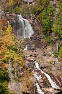 Waterfalls, White waterfalls its autumn with fall foliage bright colors of green, red, yellow, and brown, white silky water, large, stained stones on Hwy. 281 at NC/SC state line Vertical Photo
