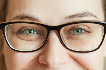 Close-up laughing eyes of a young beautiful woman in glasses