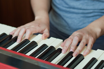 close-up of a woman's hand playing a red electronic piano
