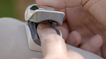 Close up shot of finger going into an oximeter to measure pulse rate and oxygen in the body