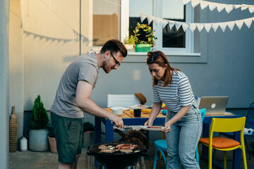 family preparing barbecue outdoor in home backyard