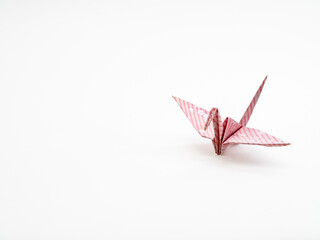 桜の花柄とピンクのストライプが入った折り紙で折った鶴