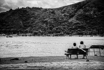 A couple enjoying the view of the bay of Paraty, State of Rio de Janeiro, Brazil, B&W. Taken with...