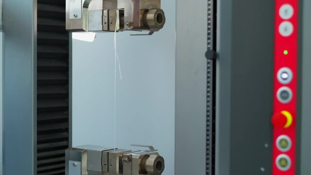 Polymer thread for plastic sack bags is tested for strength in laboratory, slow motion