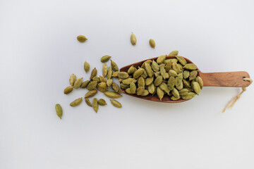 Cardamom on a wooden ladle. Pile of Indian Aromatic Spice