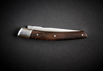 Traditional wooden pocket knife on black background