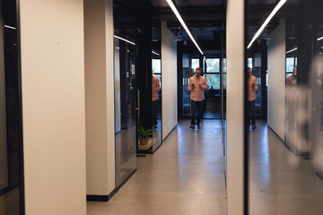 Caucasian mature businessman walking in corridor of creative office