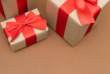 Close-up brown paper gift box red bow ribbon brown background. concept for happy love gift