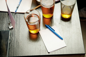 The pub quiz concept. Beer glass and blank paper for answers.