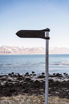 Old metal signpost near sea
