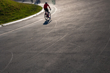 Silhouette of a biker training on the cycle-racing track in a park.