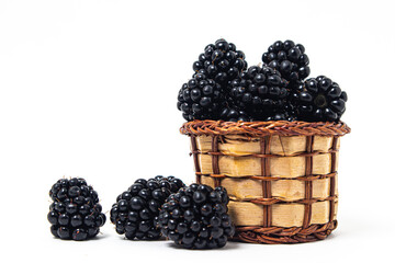 Blackberries in a basket on a white background. Healthy and tasty berry