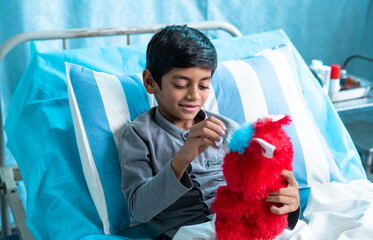 Happy sick children playing with teddy bear at hospital ward - concept of happiness, childhood...
