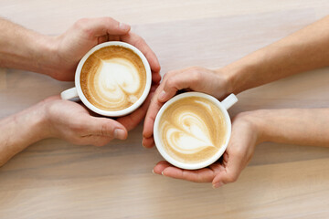 Couple drinking coffee in a cafe man and woman with a cup of hot latte. Flat lay.