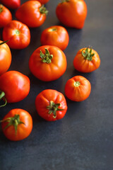 Fresh organic tomatoes, picked from the garden, on dark background. Selective focus.