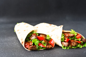 Lavash appetizer with lettuce, meat and sauce. Shawarma. Mexican tacos.