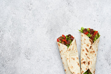 Lavash appetizer with lettuce, meat and sauce. Shawarma. Mexican tacos.