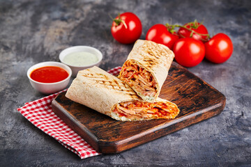 Eastern traditional shawarma with chicken and vegetables, Doner Kebab with sauces. Fast food....