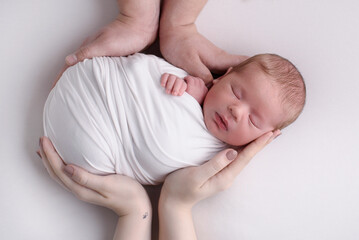 Newborn baby lying on hands of parents. Imitation of baby in womb. beautiful little girl sleeping on her back. manifestation of love. Health care concept, parenthood, children's Day, medicine, IVF