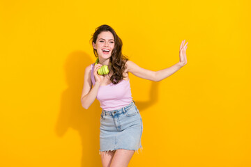Photo of cheerful nice girl toothy smile look empty space arm palm waving hi isolated on yellow color background © deagreez