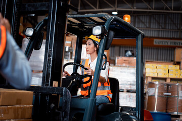 Woman warehouse worker with forklift. This is a freight distribution warehouse. logistic working at warehouse.