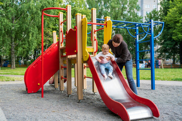 Young mother playing with her baby on the playground.